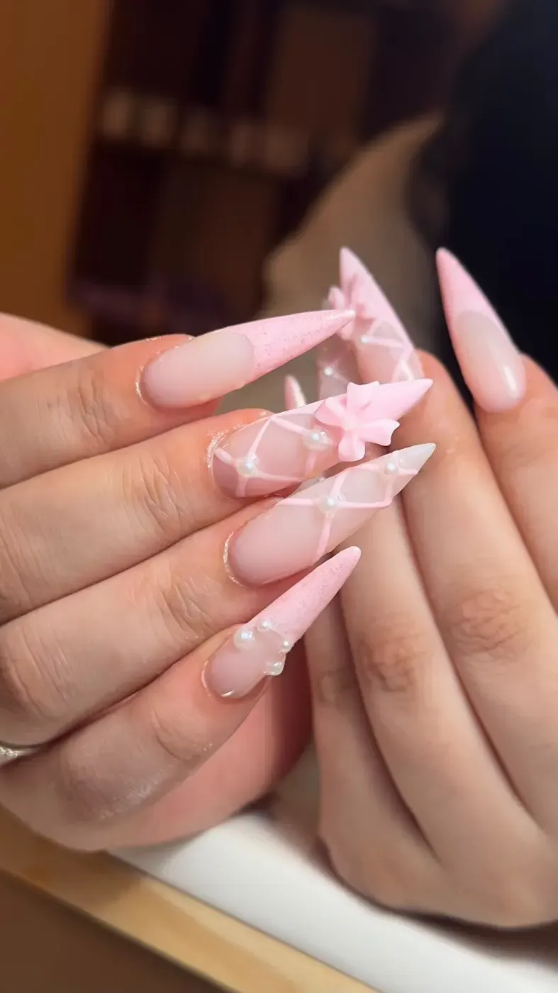 Lange roze nagels met 3D-strikjes